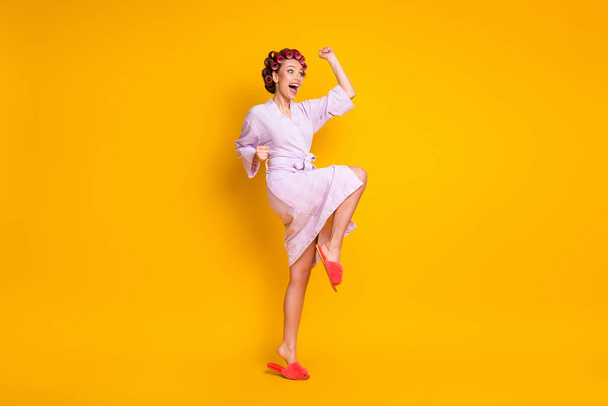 Full length body size view of pretty cheerful ecstatic woman wearing curlers celebrating dancing isolated bright yellow color background - Фото, зображення