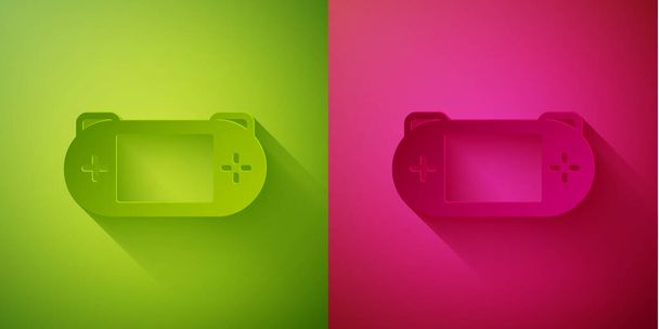 Papírvágás Hordozható videojáték konzol ikon elszigetelt zöld és rózsaszín háttérrel. Gamepad jel. Játékkoncepció. Papírművészeti stílus. Vektor. - Vektor, kép