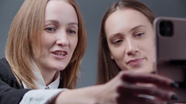 Schieten van twee vrouwelijke bloggers praten met volgers op grijze achtergrond - Video