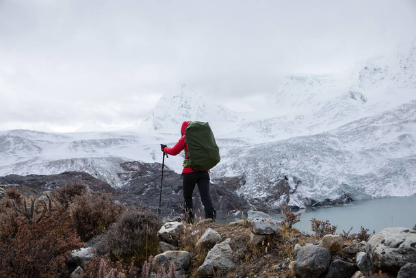 Strong woman backpacker hiking in winter mountains - Φωτογραφία, εικόνα