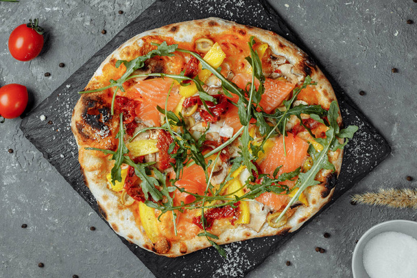 Delicious pizza with salmon and vegetables. italian pizza. - Photo, Image