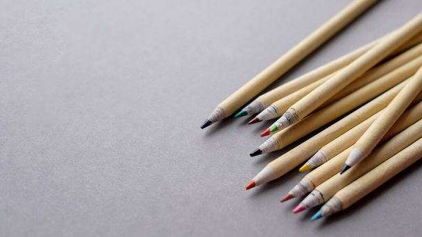 Bleistifte aus umweltfreundlichen Materialien liegen auf einem grauen Hintergrund. Es gibt einen Platz für Text. - Foto, Bild