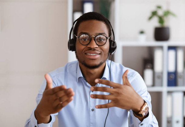 Retrato de afro-americano no fone de ouvido falando e gesticulando - Foto, Imagem