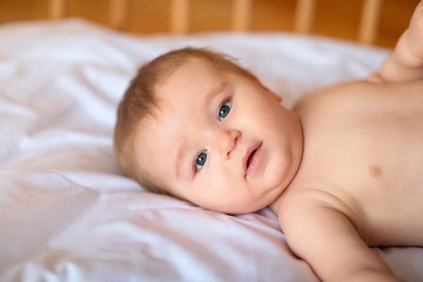 Closeup portrait of cute little baby in crib - Photo, Image