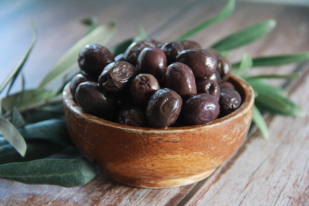 luonnon suolatut mustat oliivit koristelautasella - Valokuva, kuva