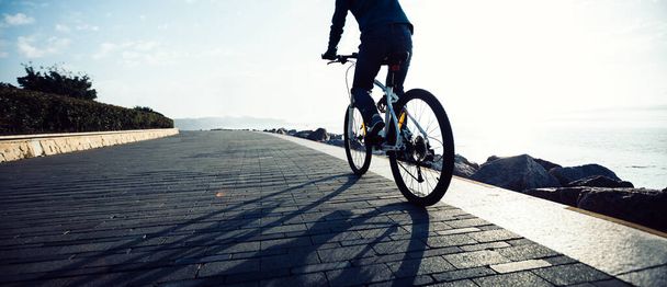 Cyclist riding bike in the sunrise coast path - Foto, Imagen