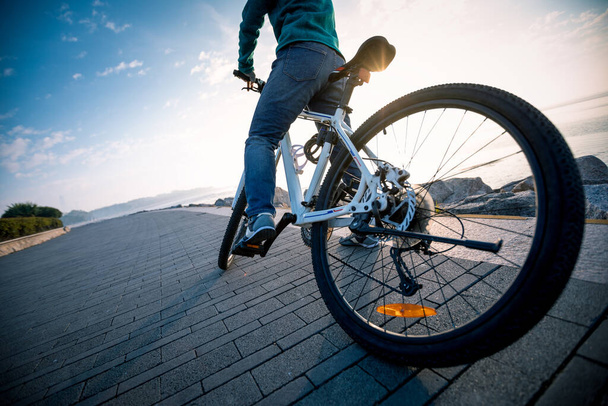 Cyclist riding bike in the sunrise coast path - Foto, immagini