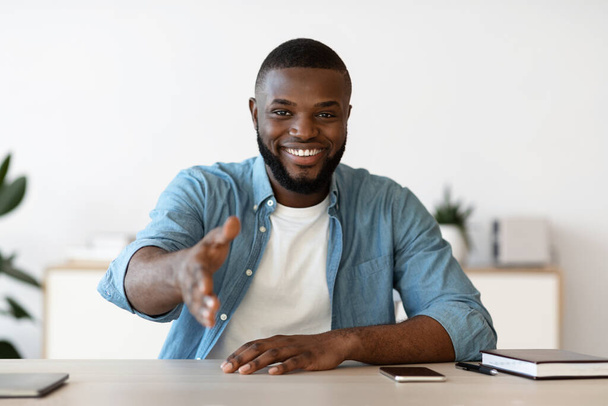 Sourire noir homme d'affaires donnant la main pour poignée de main à la caméra, offrant un partenariat - Photo, image