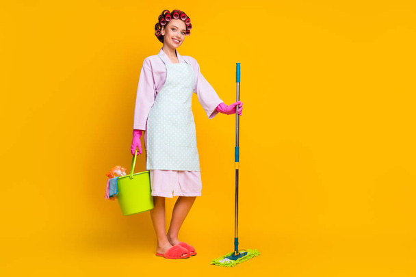 Full size photo of positive girl hold bucket mop wear bath robe gloves slippers isolated bright color background - Photo, Image