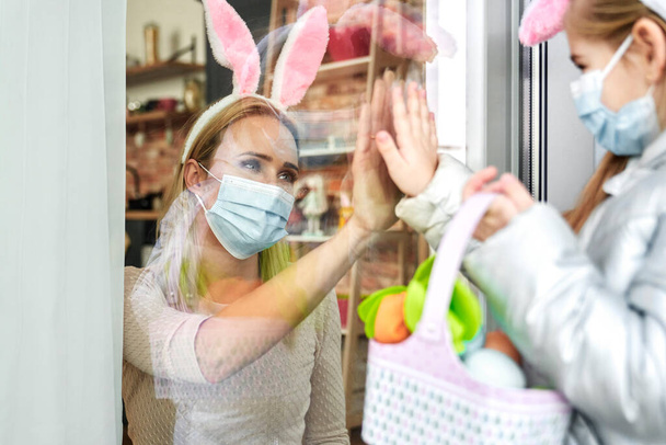 Mother greeting little daughter during the Easter quarantine                                - Photo, Image