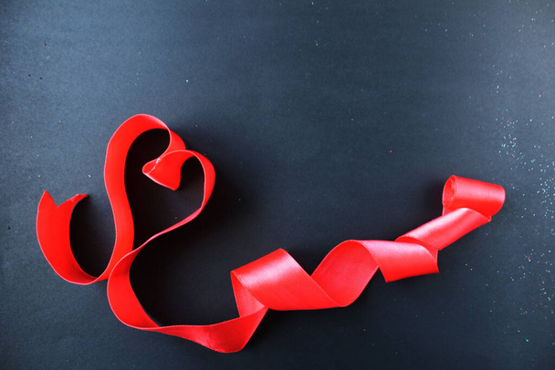 rood hart van tape met krullen op zwart grijze achtergrond met copyspace plaats voor tekst Valentijnsdag. - Foto, afbeelding