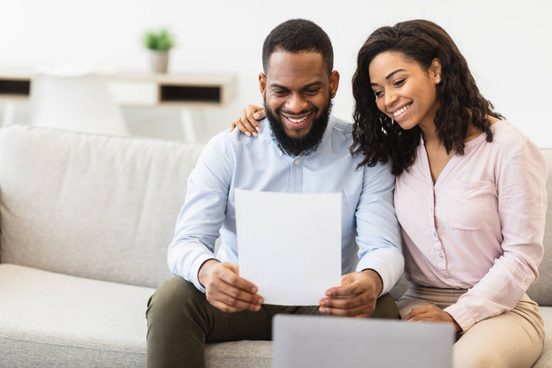 Sorrindo casal preto leitura documentação em casa, verificando acordo - Foto, Imagem