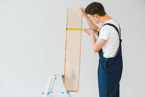 Worker with materials for installing laminate flooring - Fotó, kép