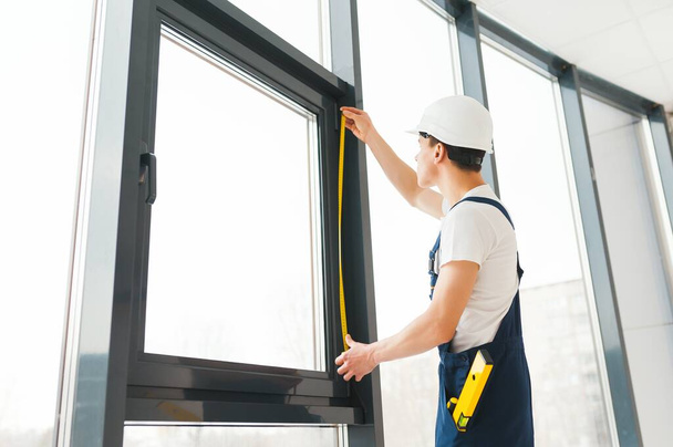 Professional handyman installing window at home. - Фото, зображення
