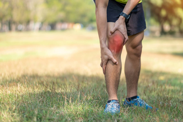 junger erwachsener Rüde mit Muskelschmerzen beim Laufen. Läufer haben Knieschmerzen aufgrund des Runners Knee oder Patellofemoral Pain Syndrome, Arthrose und Patellarsehnenentzündung. Sportverletzungen und medizinisches Konzept - Foto, Bild