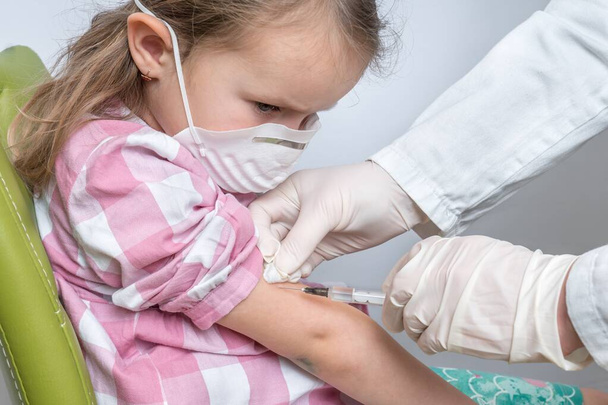 Az orvos beoltott egy kislányt a Covid-19 elleni védelem érdekében - vakcinázási koncepció - Fotó, kép
