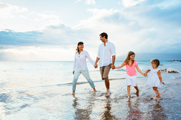 szczęśliwą rodziną bawić się na spacery na plaży o zachodzie słońca - Zdjęcie, obraz