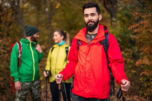 Bearded traveler near friends in autumn forest - Zdjęcie, obraz