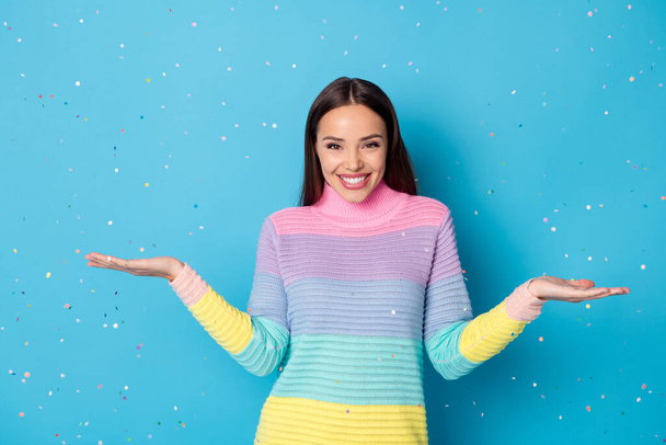Photo of candid girl enjoy air fall fly confetti wear pullover isolated over blue color background - Fotó, kép