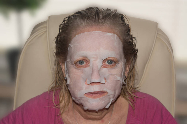 Terapia de spa para mujer recibiendo mascarilla facial en salón de belleza - Foto, imagen