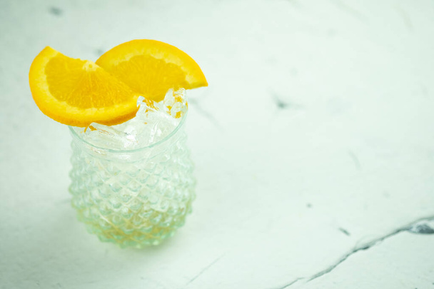 Copo de cubos de gelo e fatias de laranja. Bebida fresca e fria - Foto, Imagem