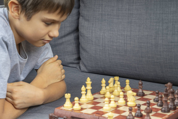 Teenager beim Schachspiel zu Hause. Bildung, strategisches Brettspiel, Bildung, Freizeit, Unterhaltung zu Hause - Foto, Bild