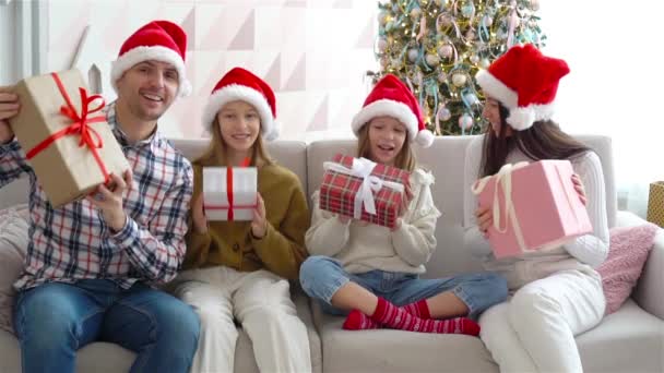 Szczęśliwa młoda rodzina z dziećmi gospodarstwa prezenty świąteczne - Materiał filmowy, wideo