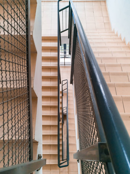 Felülről lefelé néző modern lépcsőház könnyű lépcsők és fém korlátok - Fotó, kép