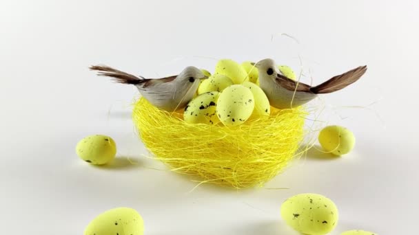 Pääsiäisen tausta keltainen pesä keltaisilla munilla valkoisella taustalla. Pääsiäisloma. Kevätkonsepti 4K - Materiaali, video