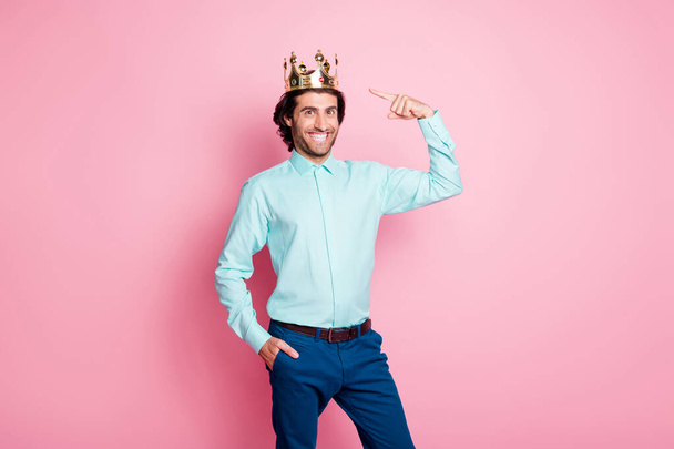 Photo portrait of man pointing finger at crown on head isolated on pastel pink colored background - Foto, Bild