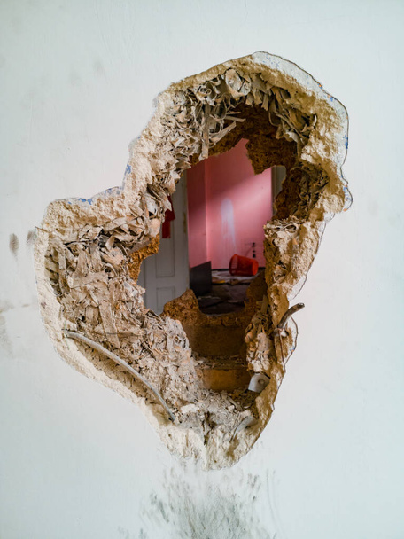 Pequeño agujero en la pared de madera gruesa de la vieja casa de alquiler - Foto, imagen