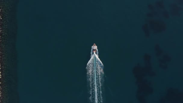 Рыбацкая лодка врезается в волны в открытом море оставляя след Уайткэп, отслеживая воздушный вид - Кадры, видео