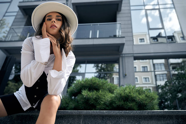 Fashionable woman posing near city office building. - Foto, afbeelding