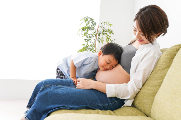 маленький мальчик и его беременная мать  - Фото, изображение
