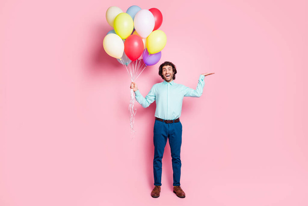 Photo portrait full body view of man holding blank space in hand with air balloons isolated on pastel pink colored background - Valokuva, kuva