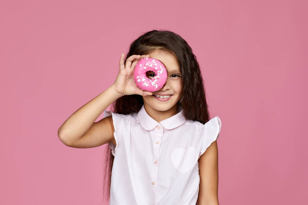 smiling child girl holding yummy donut - Фото, зображення