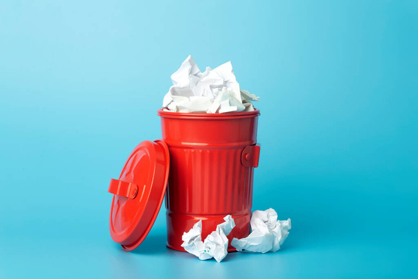 Papírový koš a odpad v odpadkovém koši na modrém pozadí. Koncept třídění a recyklace odpadu a papíru - Fotografie, Obrázek