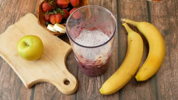 reggeli friss gyümölcsökkel és joghurttal lédús banán hátterében - Felvétel, videó