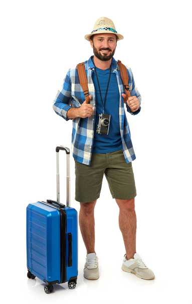 Vidám férfi hátizsák, bőrönd és fényképezőgép fehér háttér - Fotó, kép