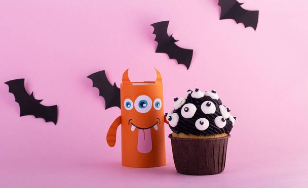 paper ghosts with a mystical cupcake for Halloween. Creative Halloween background with sweets - 写真・画像