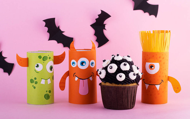 paper ghosts with a mystical cupcake for Halloween. Creative Halloween background with sweets - Zdjęcie, obraz