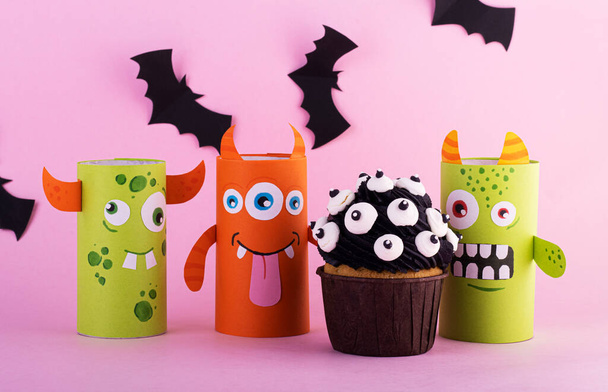 paper ghosts with a mystical cupcake for Halloween. Creative Halloween background with sweets - Zdjęcie, obraz