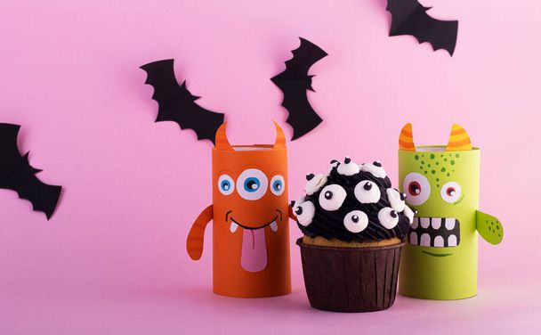 paper ghosts with a mystical cupcake for Halloween. Creative Halloween background with sweets - Fotografie, Obrázek