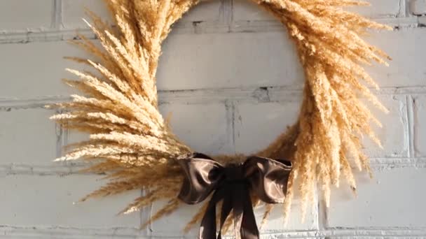 A wreath of dried flowers on a background of a white brick wall. Vintage. Interior wreath. Dried flowers as an element of home decor - Footage, Video