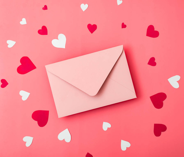 Love letter. Pink envelope on a red background with hearts. - Foto, Imagem