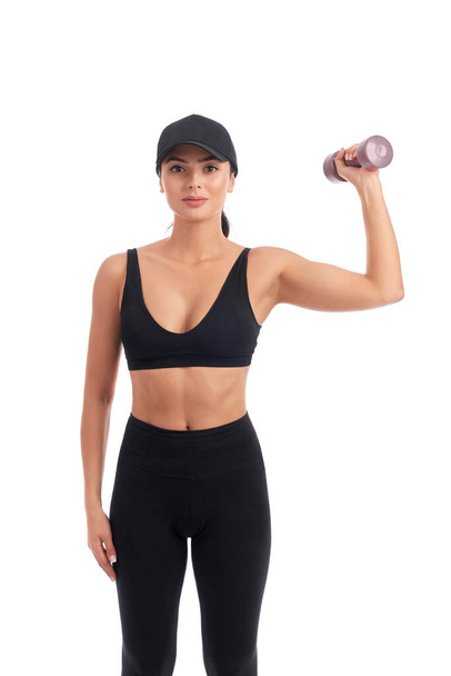 Young athletic woman in black sports wear holding dumbbell - Foto, Imagem