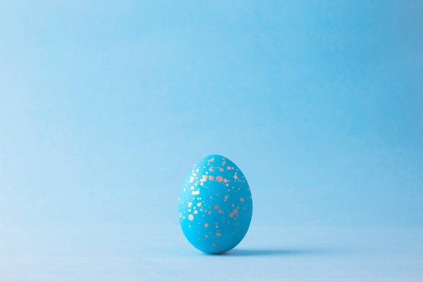 Easter egg painted in blue and golden color. Closeup, copy space for text - Zdjęcie, obraz
