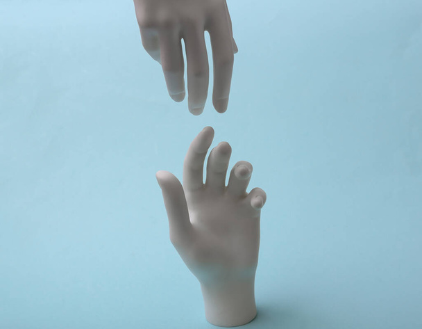 Белые руки манекена касаются друг друга на синем фоне. Минимализм. Концепт-арт - Фото, изображение