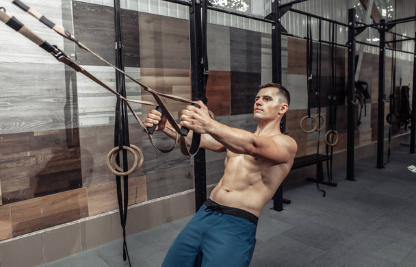 Modern bir kros kulübünde trx direnç sistemiyle egzersiz yapan kaslı bir adam. Fonksiyonel eğitim - Fotoğraf, Görsel