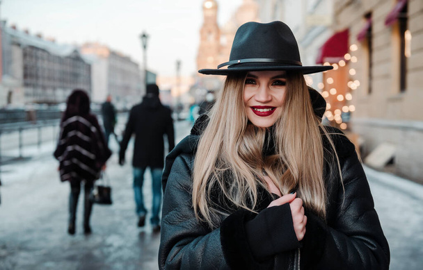 1 white beautiful blonde woman in a black hat with a wide brim on the street in the city - Φωτογραφία, εικόνα